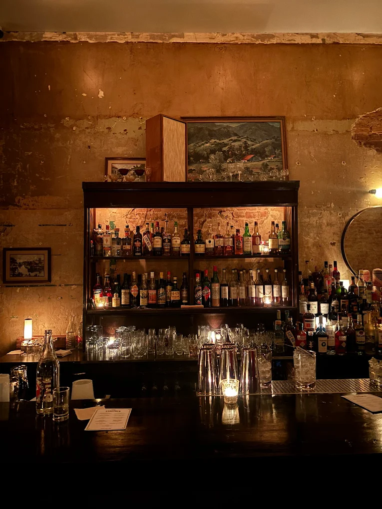 Backlit shelves of spirits behind the bar