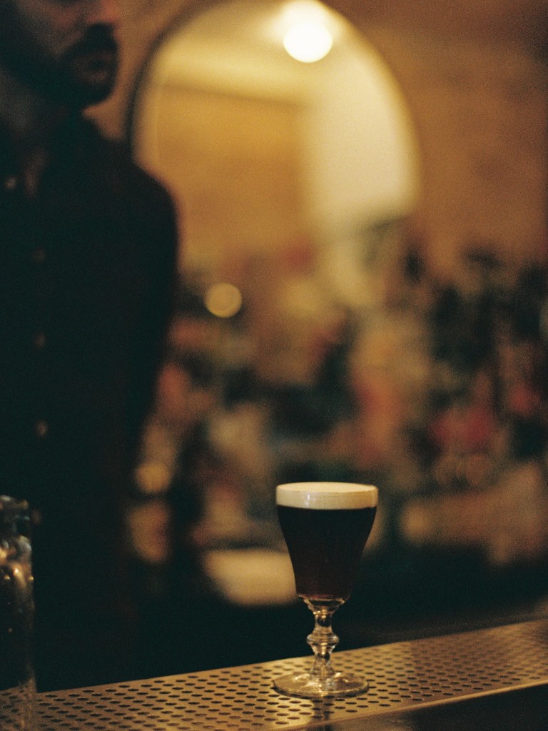 Dark cocktail with a creamy foam head