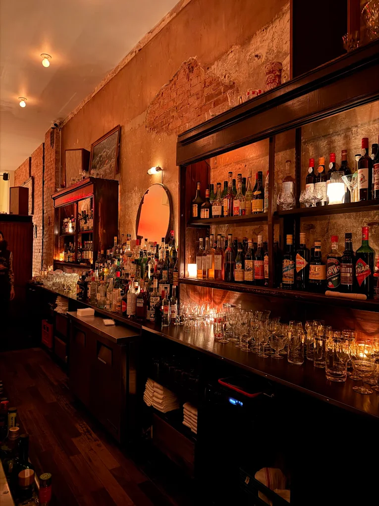 Warmly lit bar interior with bottles and glassware